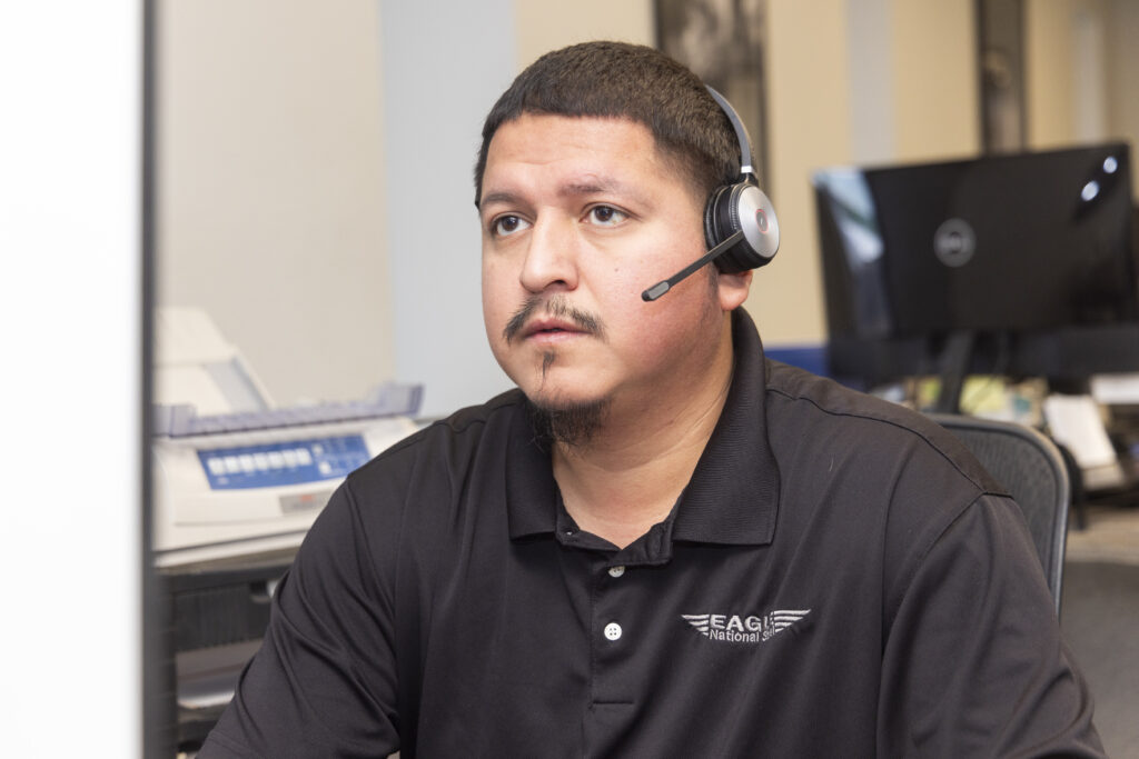 A man taking a call with a headset at Eagle Steel