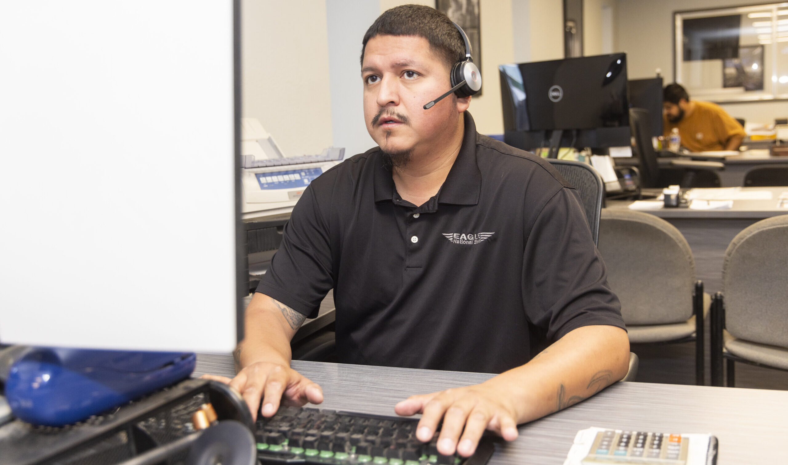 A man working on a computer wearing a headset